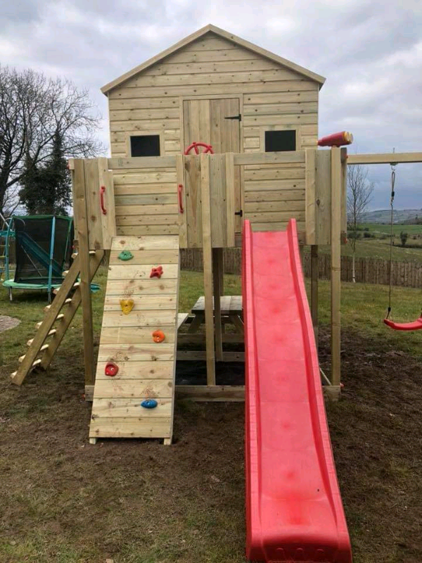 outdoor playhouse with climbing wall